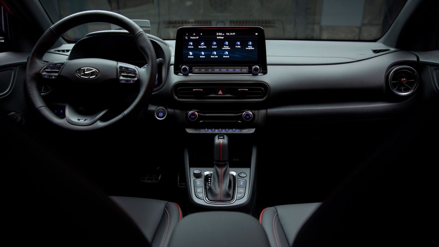 The interior of a car with a steering wheel and a dashboard.