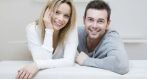 A couple on a couch smiling