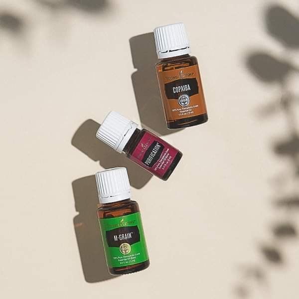 Three bottles of young living essential oils are sitting on a table.