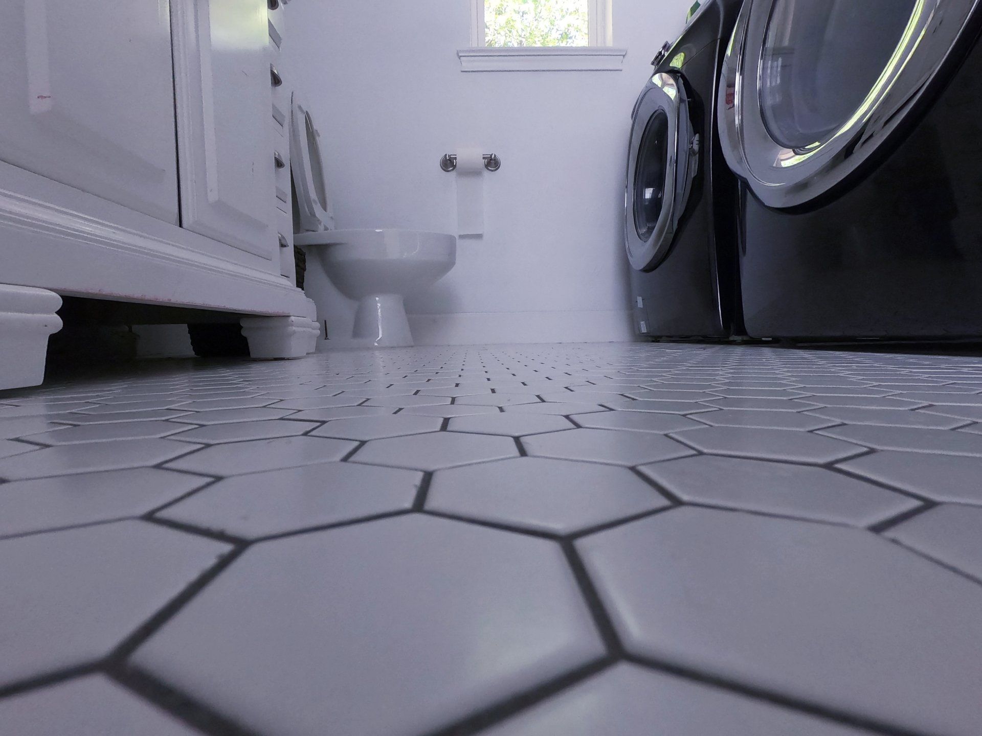 Custom tile flooring work in a custom laundry room build addition with bathroom remodeling featuring custom cabinets in Lake Highlands Dallas neighborhood.
