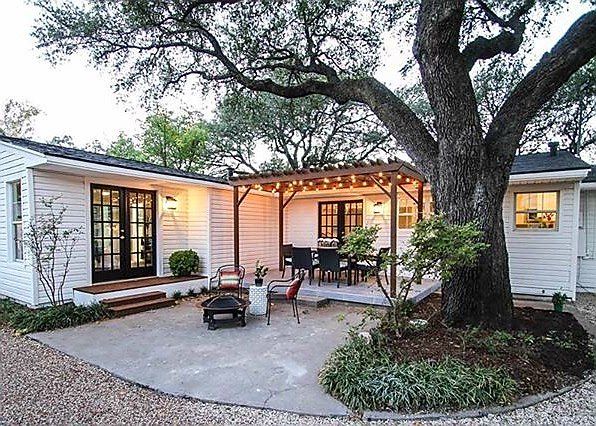 Elevated exterior living backyard patio with custom pergola and outdoor seating under large shade tree in Plano TX