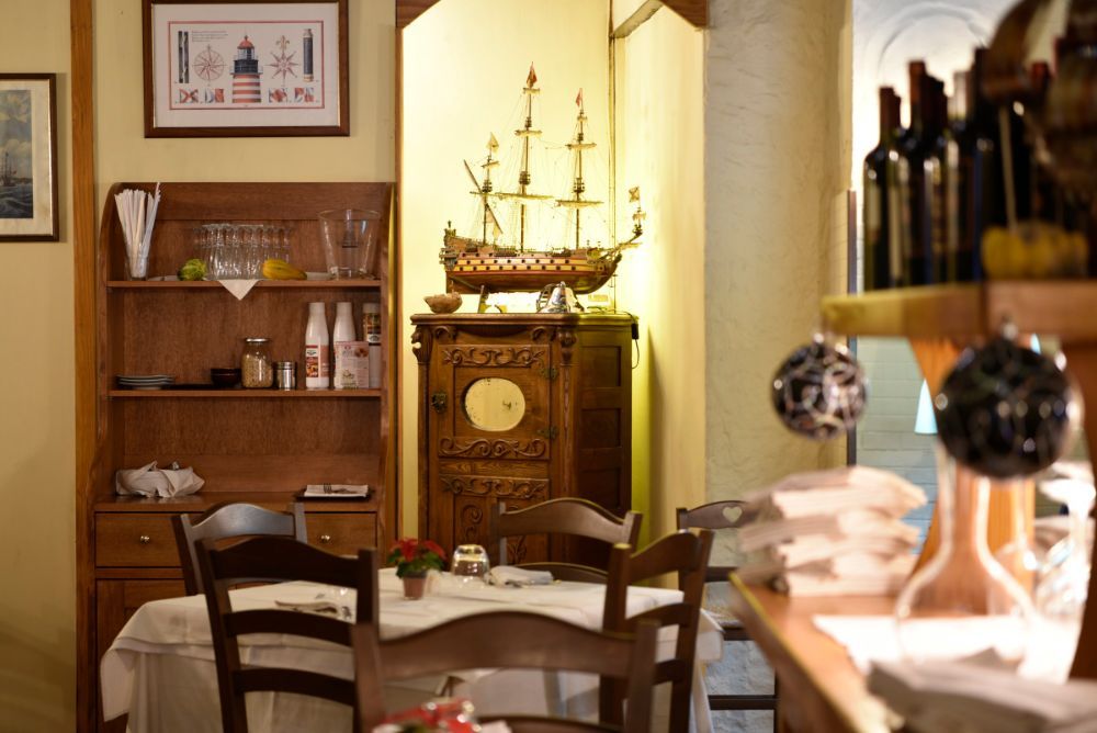 ristorante con arredi in legno e piccolo veliero