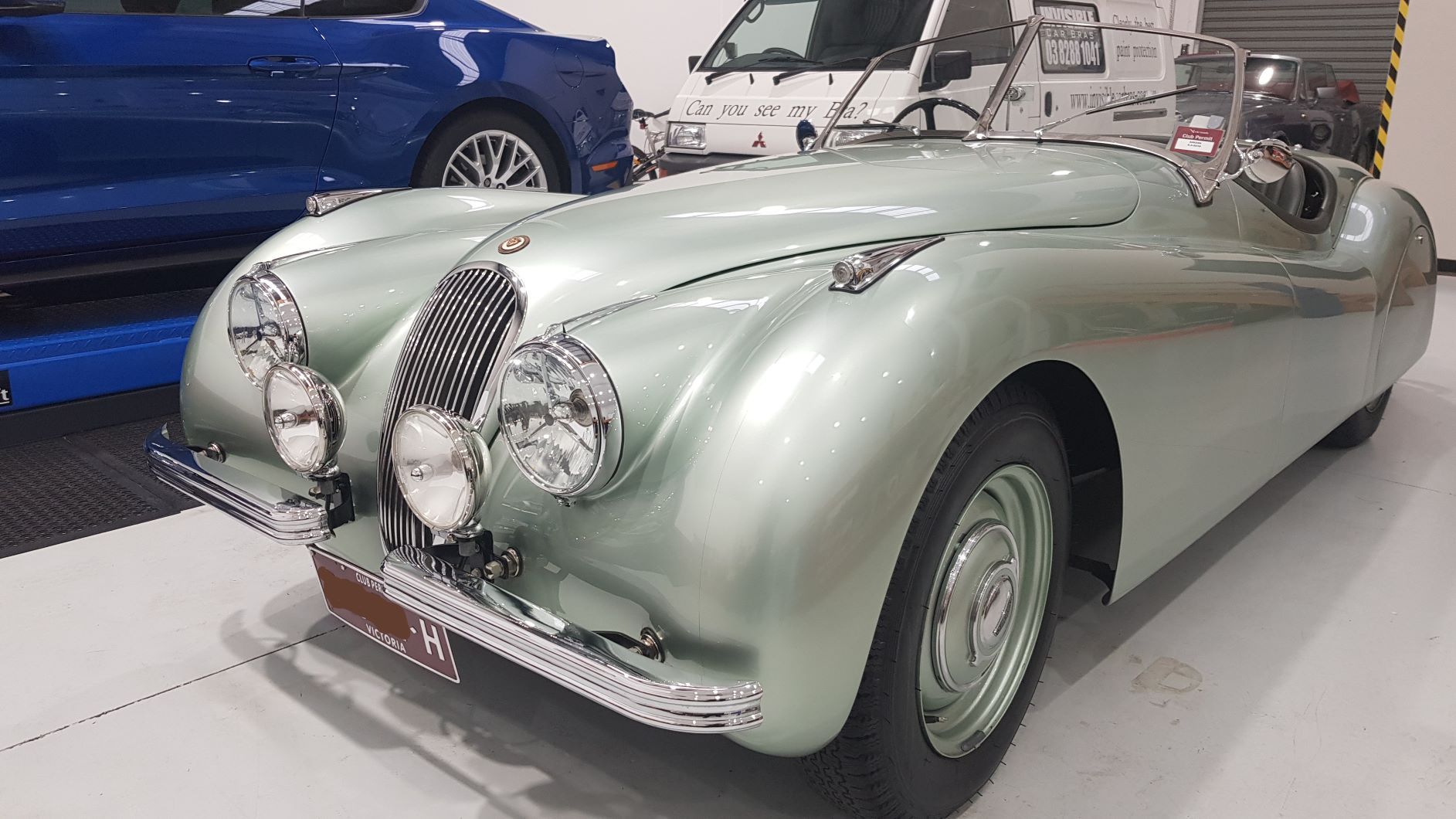 shows a silver 1950s Jaguar XK120 roadster