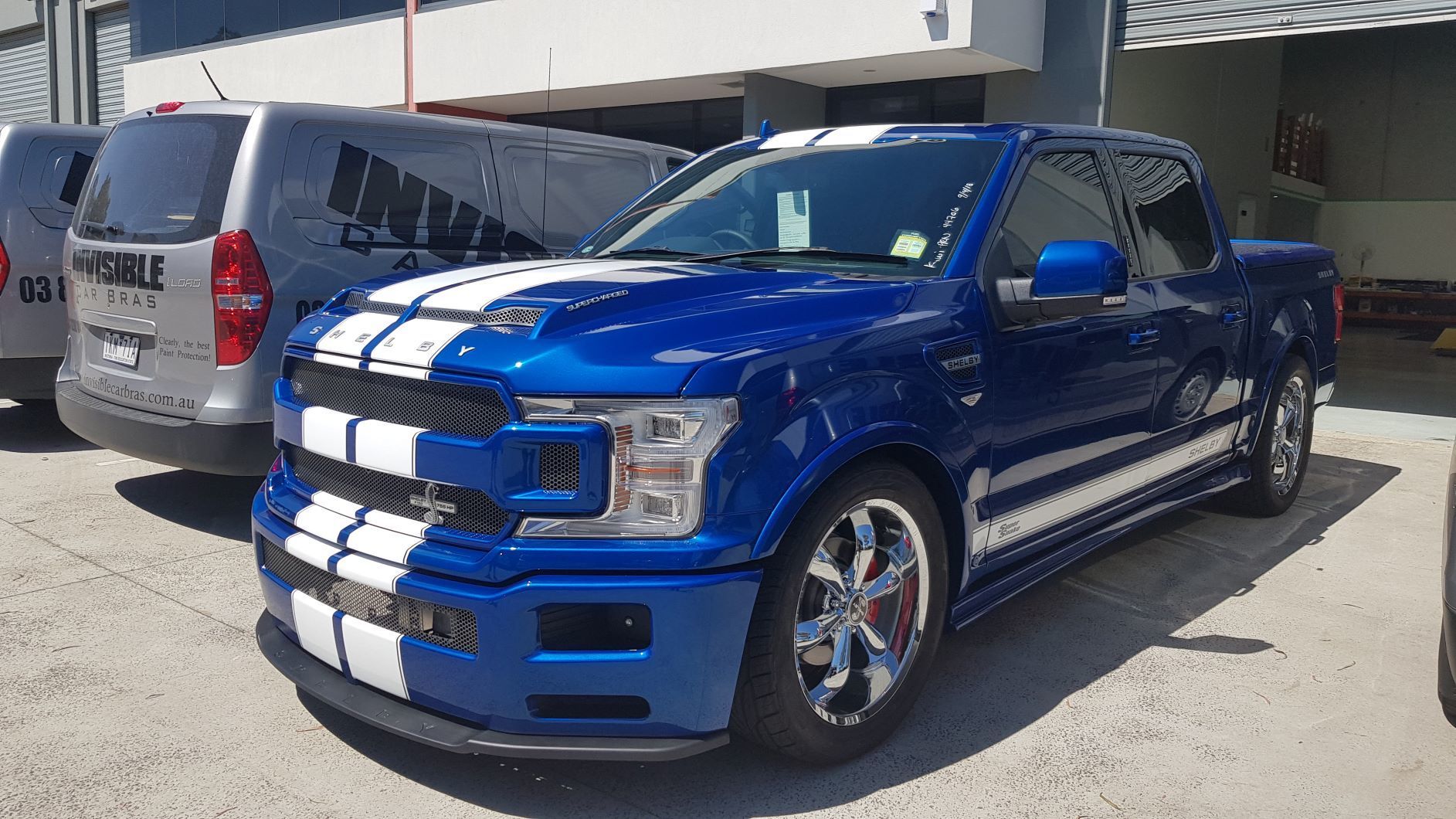 blue 2019 Ford F-150 Shelby Super Snake truck with white racing stripes parked outdoors