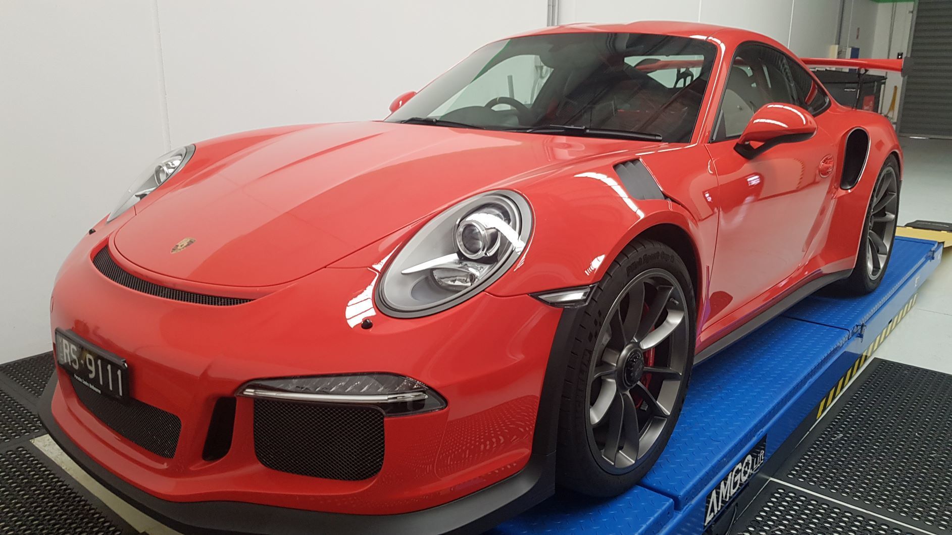 red Porsche 911 GT3 parked on a blue lift platform
