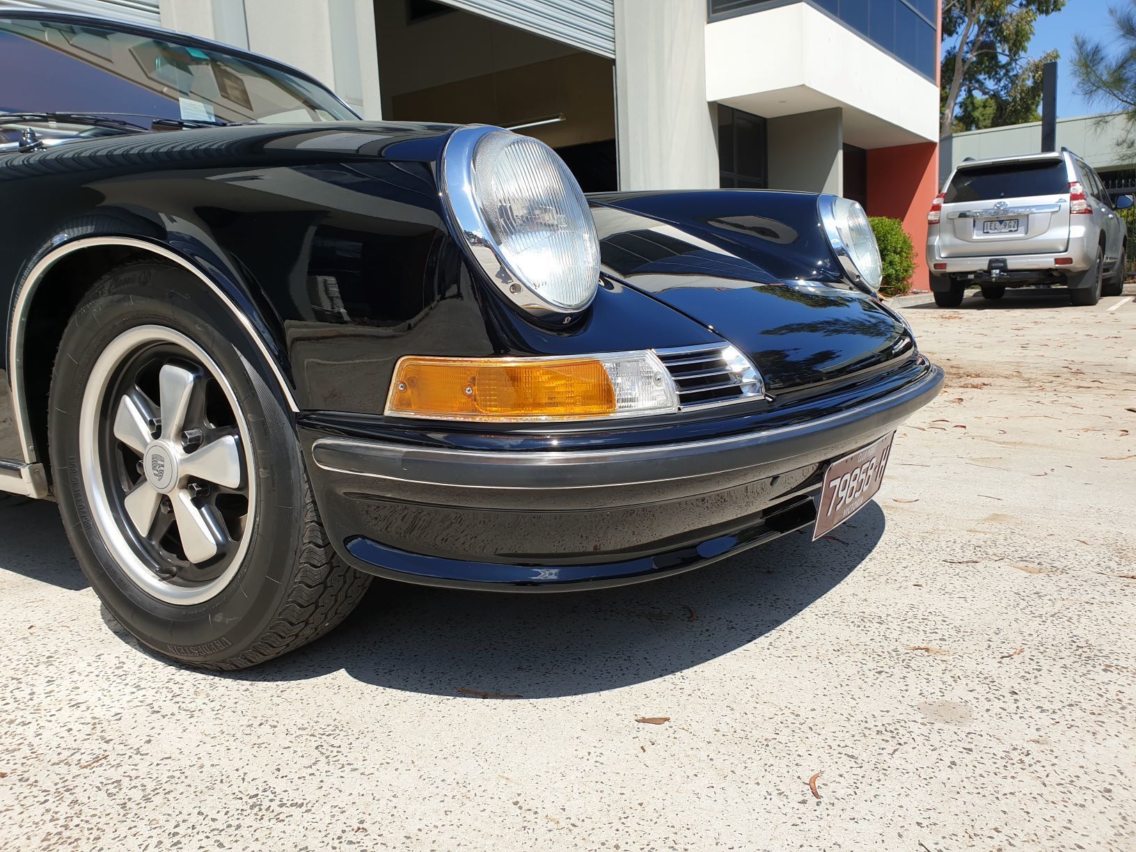 close-up of the front left side of a black classic Porsche 911