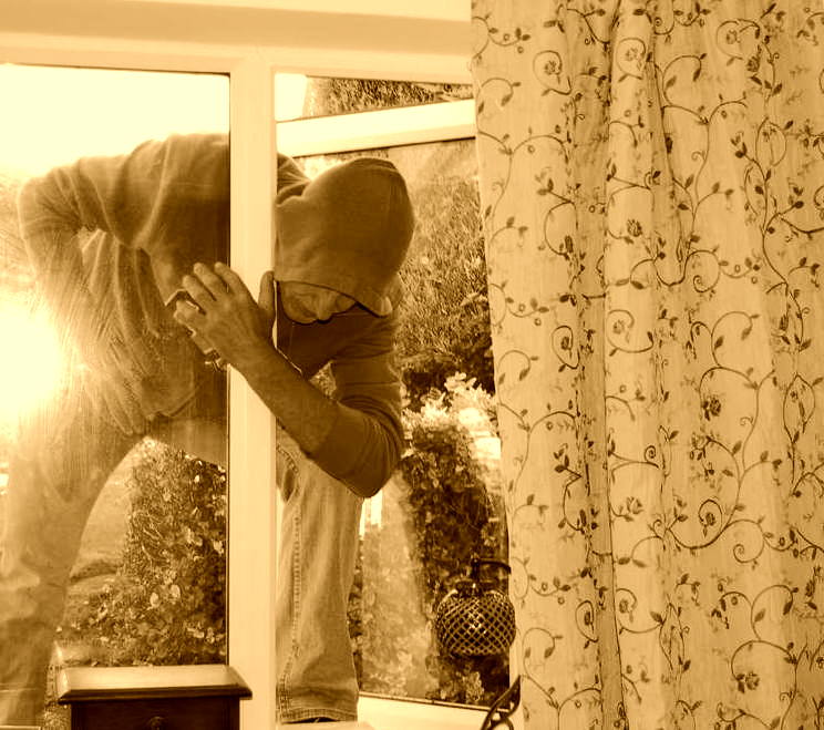 Burglar entering through a window CJ Locksmiths Chepstow