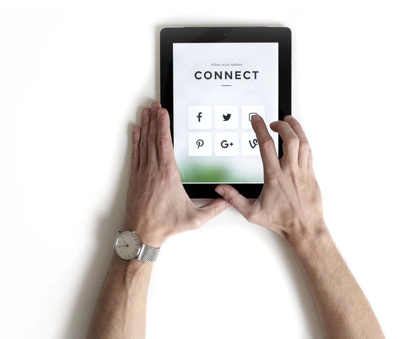 Hands holding a tablet displaying a