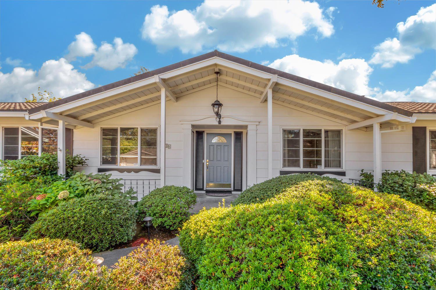 Inviting white house with a porch & bushes. Sell my House in Greenhaven-Pocket, Sacramento, CA w/ Catricala Real Estate Group