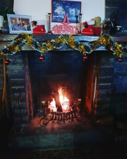 Un camino con decorazioni natalizie e un cartello con la scritta Buon Natale