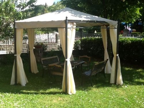 Un gazebo con un tavolo e delle sedie sottostanti