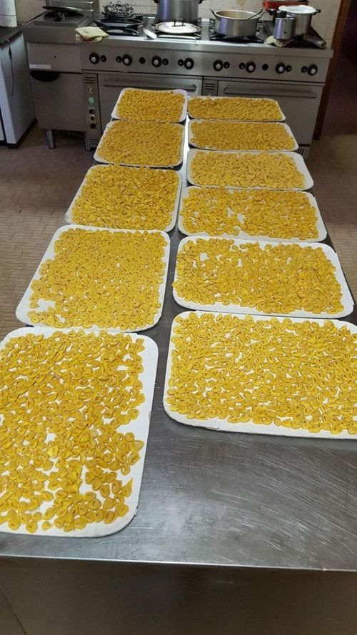 Ci sono molti vassoi di maccheroni e formaggio sul tavolo.