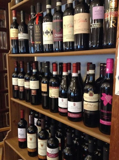 Uno scaffale pieno di bottiglie di vino, tra cui una con la scritta