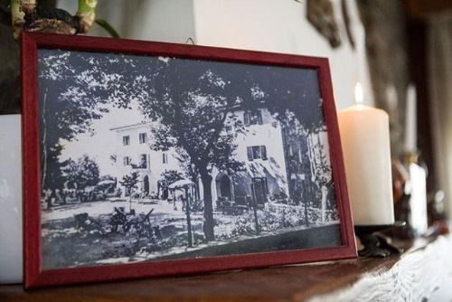 Una foto in bianco e nero in una cornice rossa è su un tavolo accanto a una candela.
