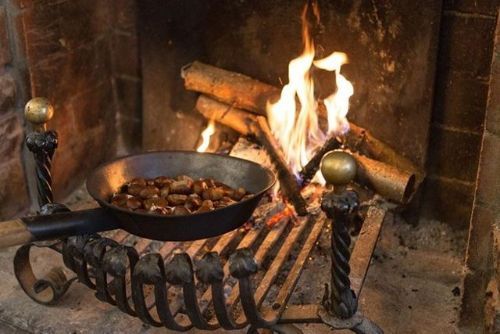 Una pentola di cibo cuoce davanti al camino.