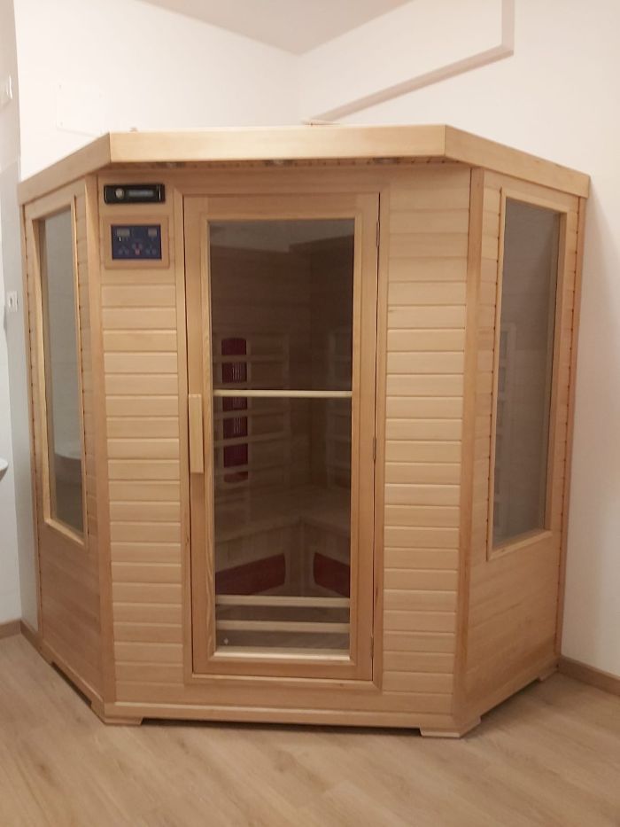 Una sauna in legno è posizionata nell'angolo di una stanza
