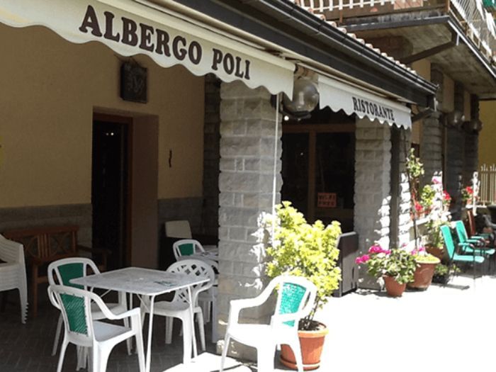 Un ristorante chiamato Albergo Poli ha tavoli e sedie all'esterno