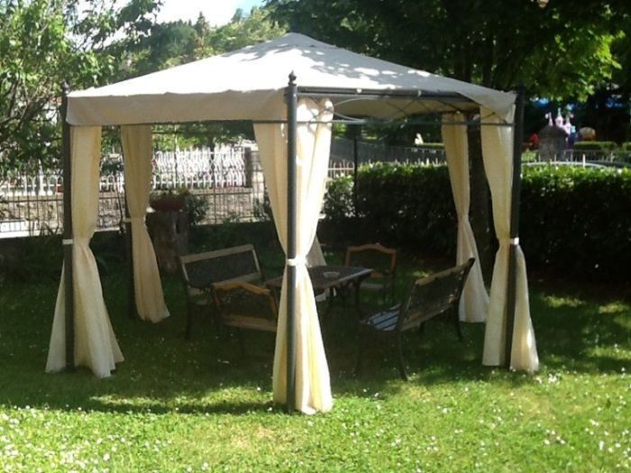 Un gazebo con un tavolo e delle sedie sottostanti in un albergo con ristorante a Bologna