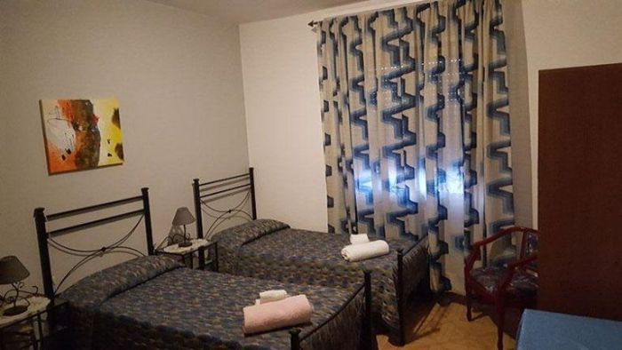 Una camera da letto con due letti e un quadro sul muro