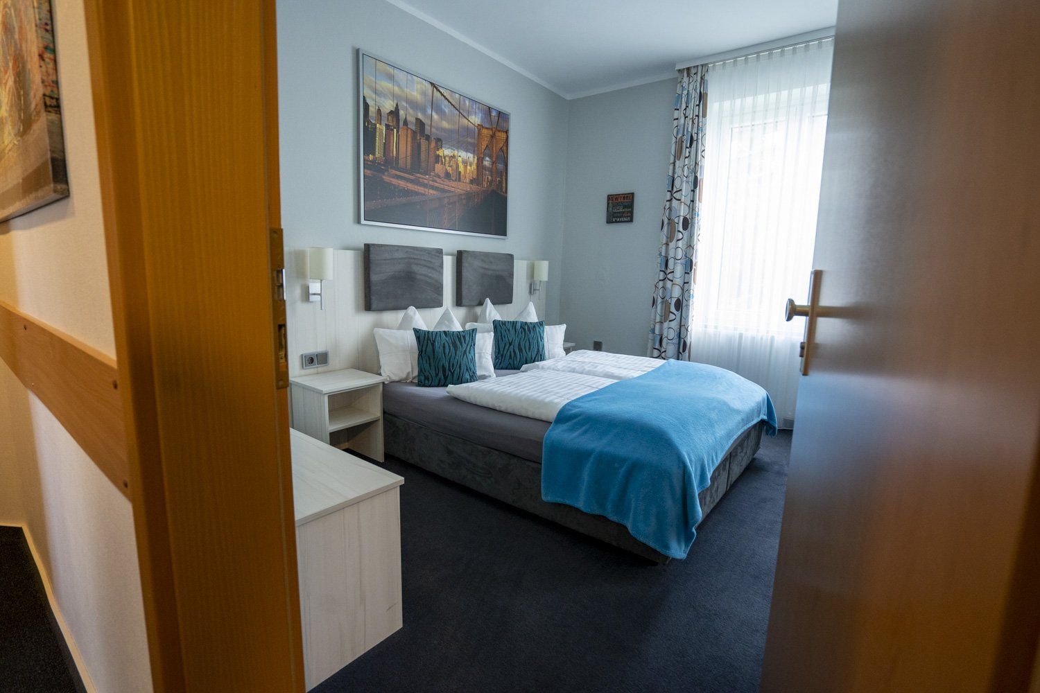 Ein Hotelzimmer mit zwei Betten und einem Fenster.