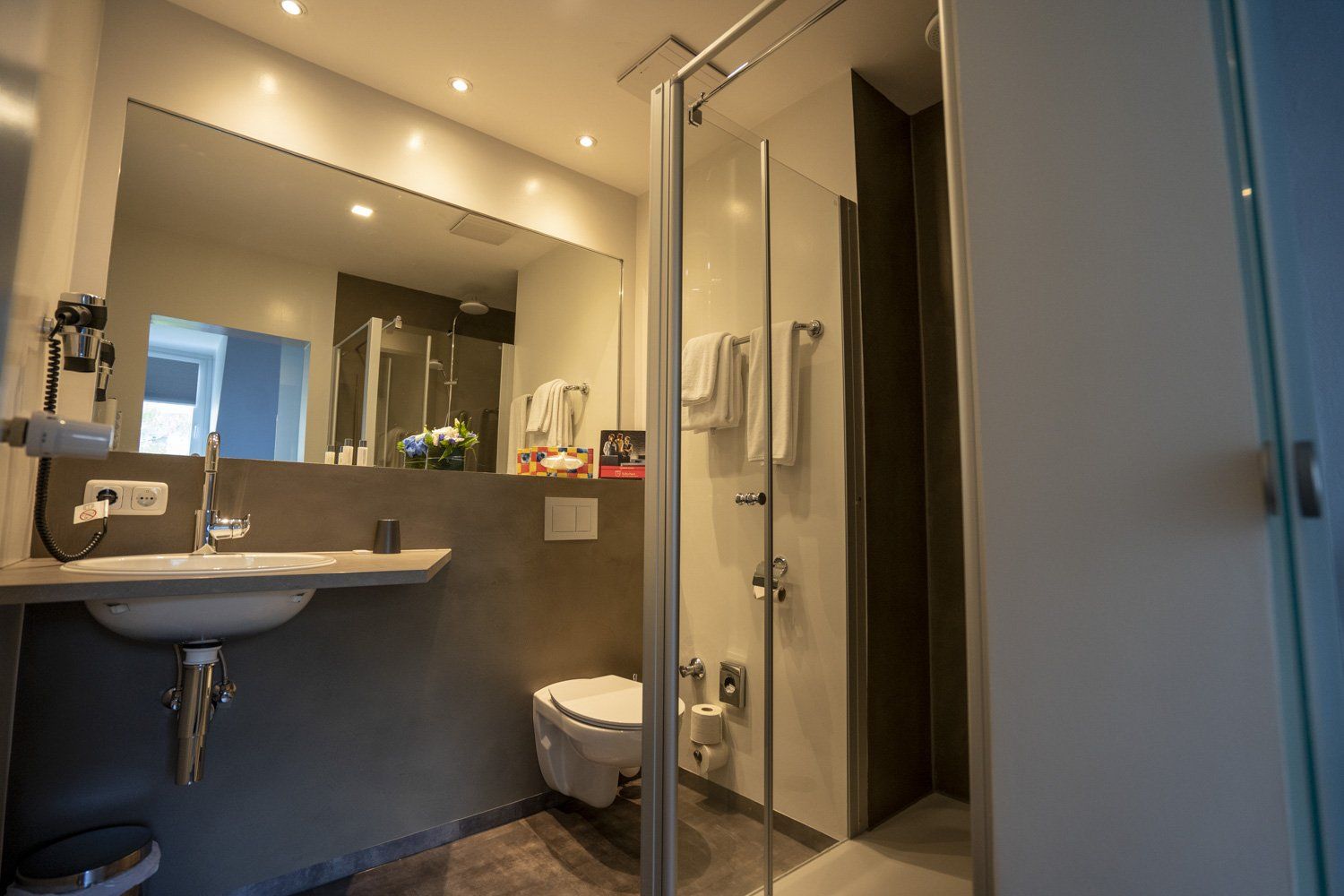 Ein Badezimmer mit Waschbecken, Toilette, Dusche und Spiegel.