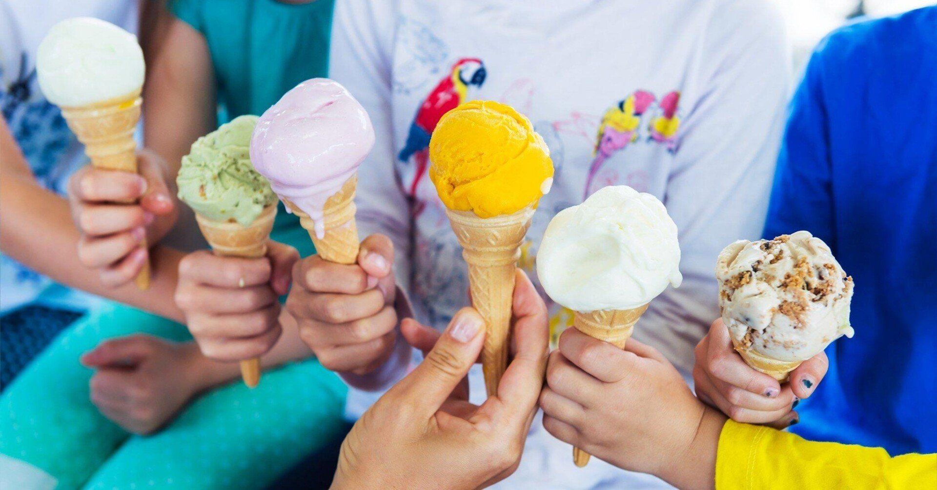 Children holding up various colorful ice cream cones.
