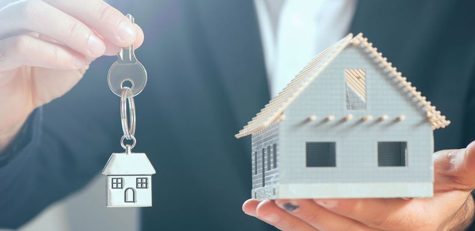 hands holding house and key
