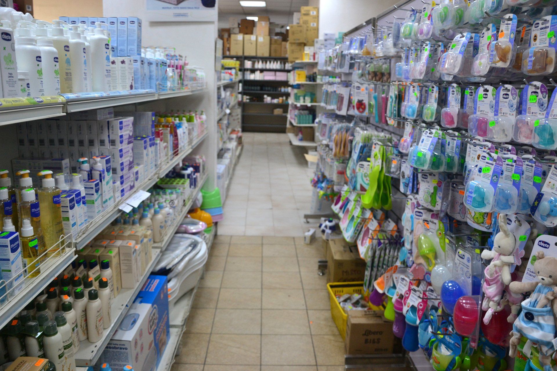 Corsia di un negozio per bambini rifornita di prodotti per il bagno, ciucci e biberon.