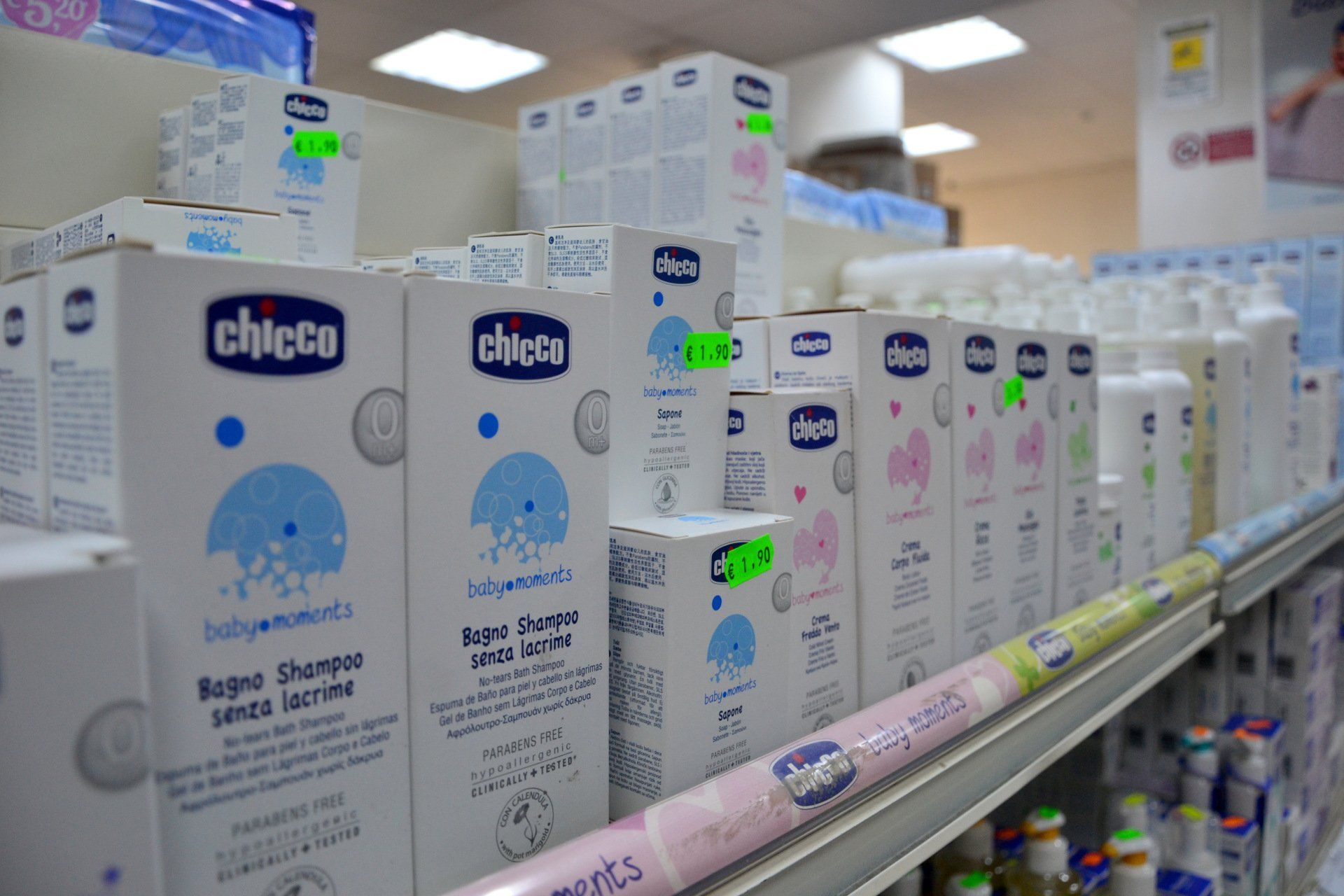 Scaffali pieni di shampoo per bambini Chicco e prodotti correlati in un negozio.