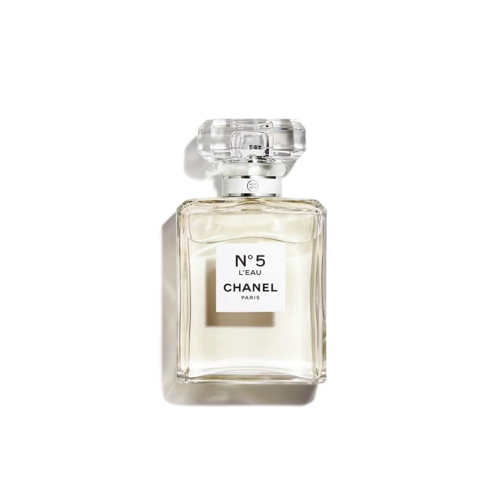 Flacone di profumo Chanel n. 5. Vetro trasparente, forma rettangolare con etichetta bianca. Tappo argentato.
