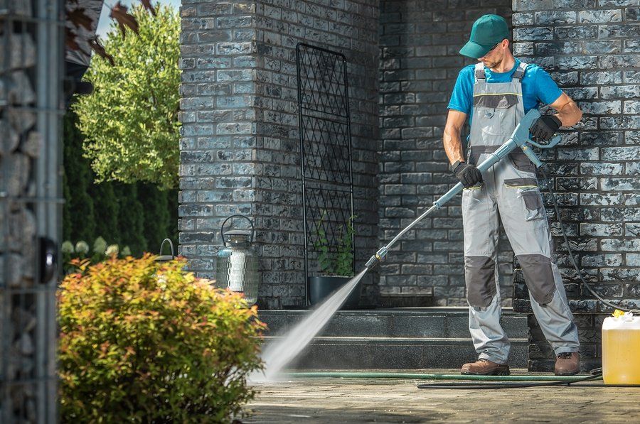man spraying water outside the house