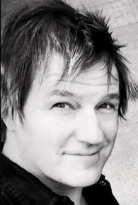 A black and white photo of a young man smiling.