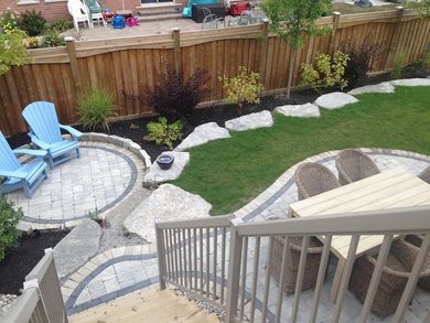 A backyard with a table and chairs and a wooden fence
