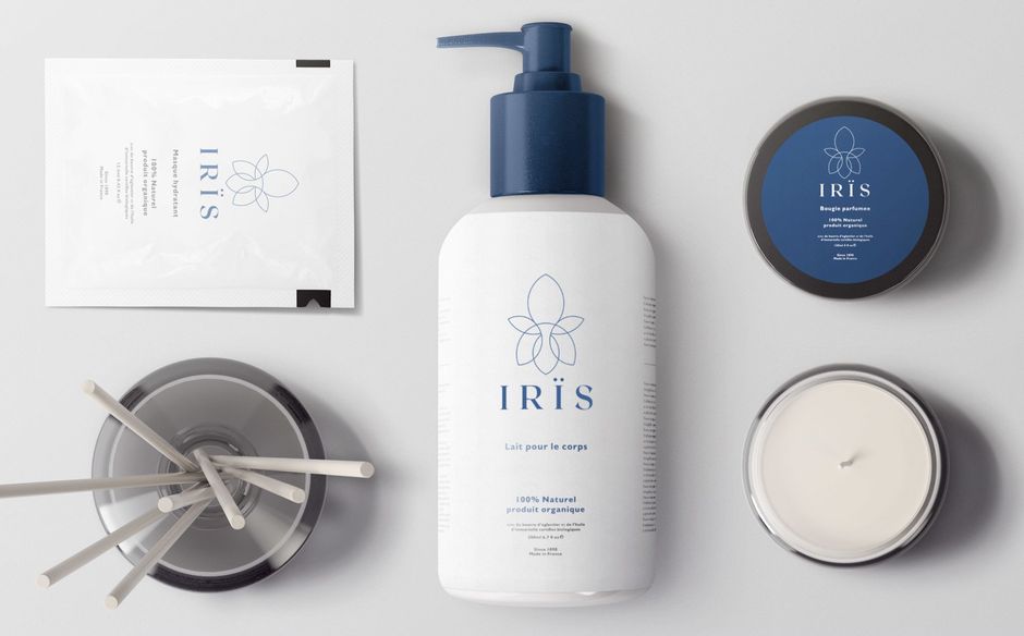 White cosmetic products with dark blue accents, and an iris logo on a light gray surface.