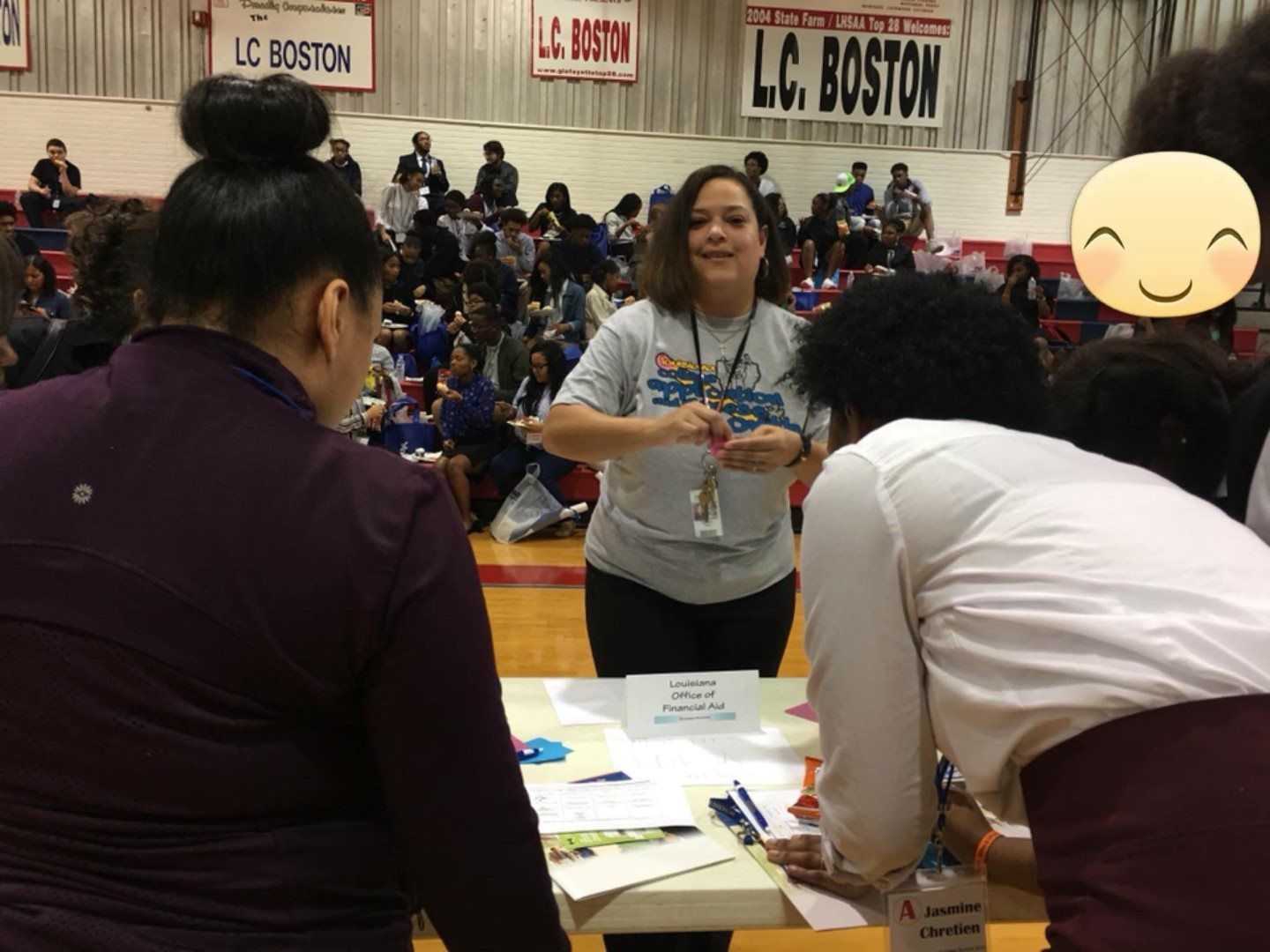 A woman is standing in front of a table with a sign that says l.c. boston on it.