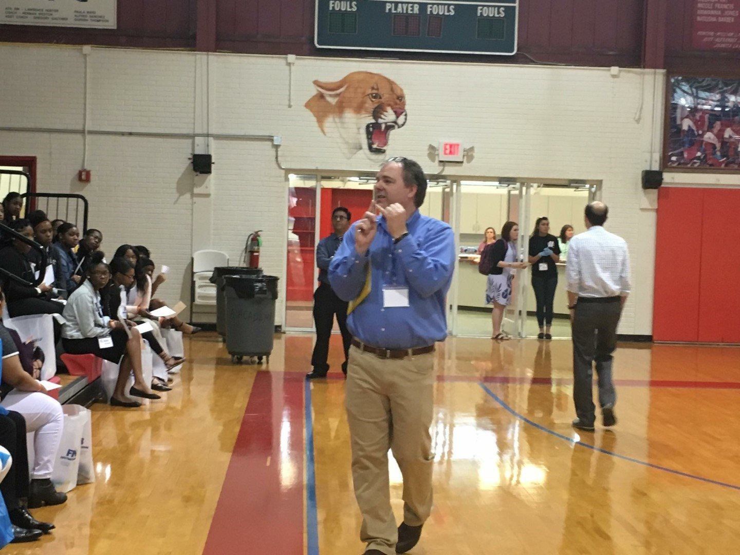 A man speaking into a microphone in a gym