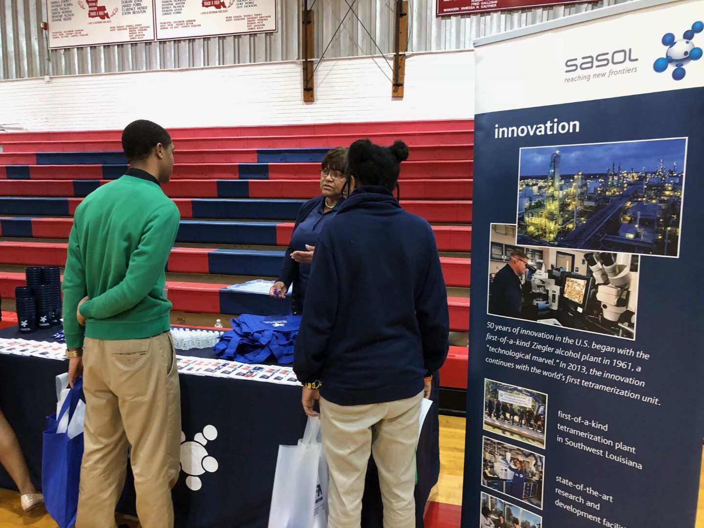 A group of people are standing around a table at a job fair.