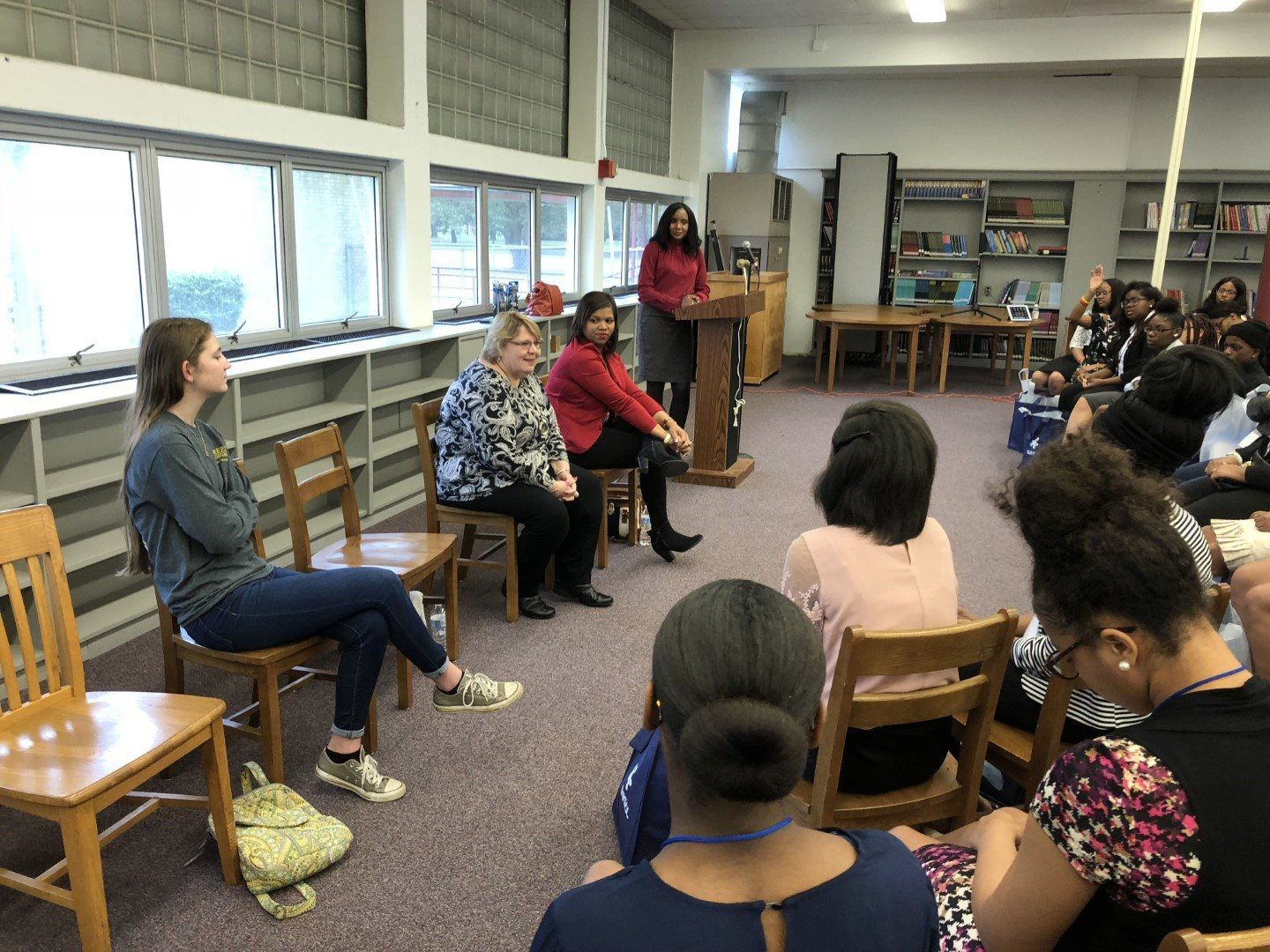 A group of women are sitting in a circle in a library.