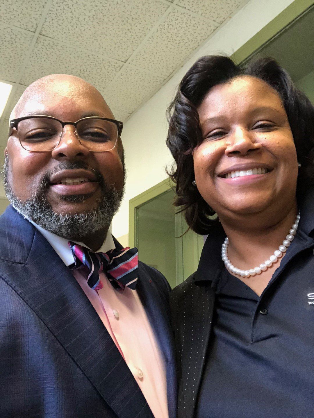 A man and woman are posing for a picture and the man is wearing a bow tie