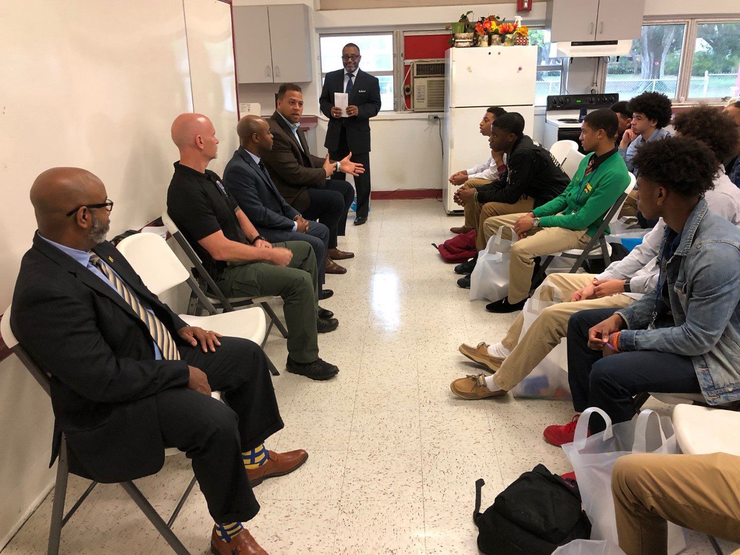 A group of men are sitting in a circle in a room.