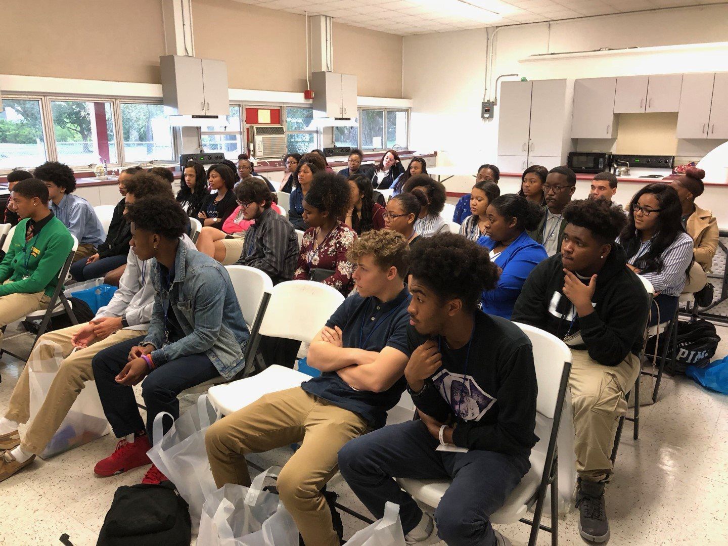 A group of people are sitting in chairs in a room.