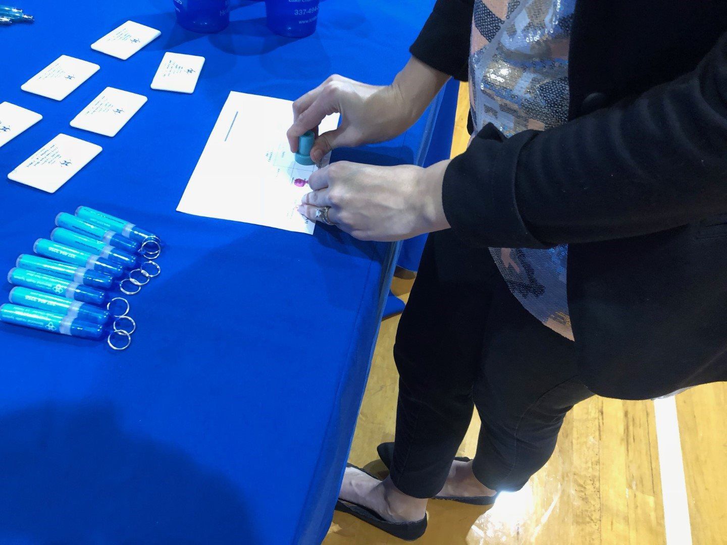 A woman is putting a stamp on a piece of paper.