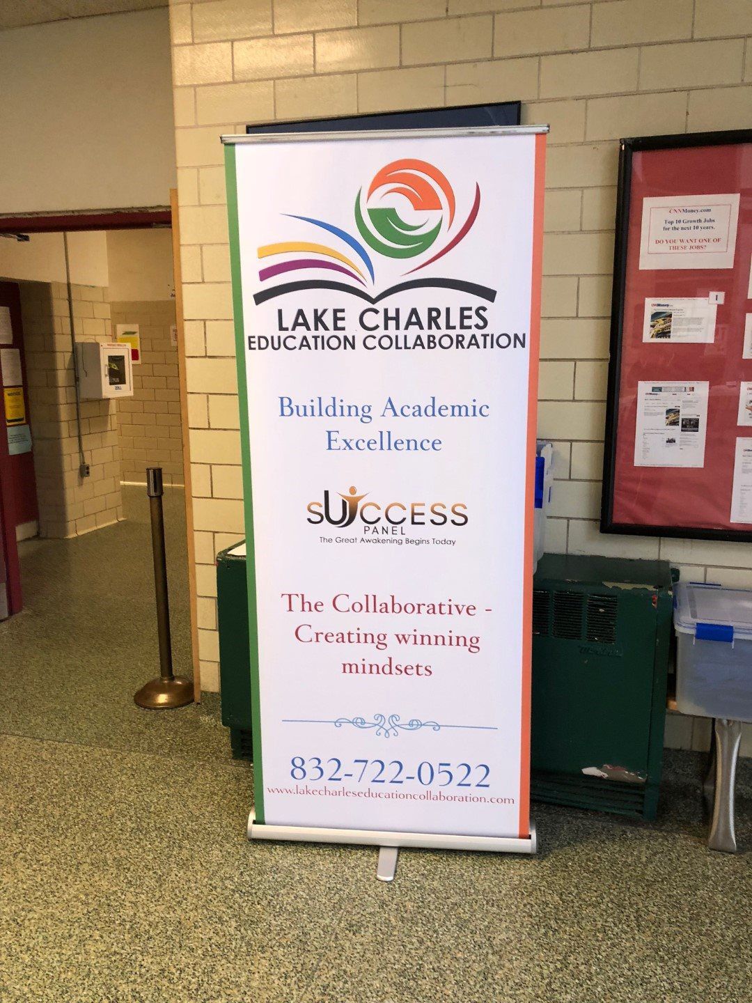 A sign in a hallway that says lake charles education collaboration