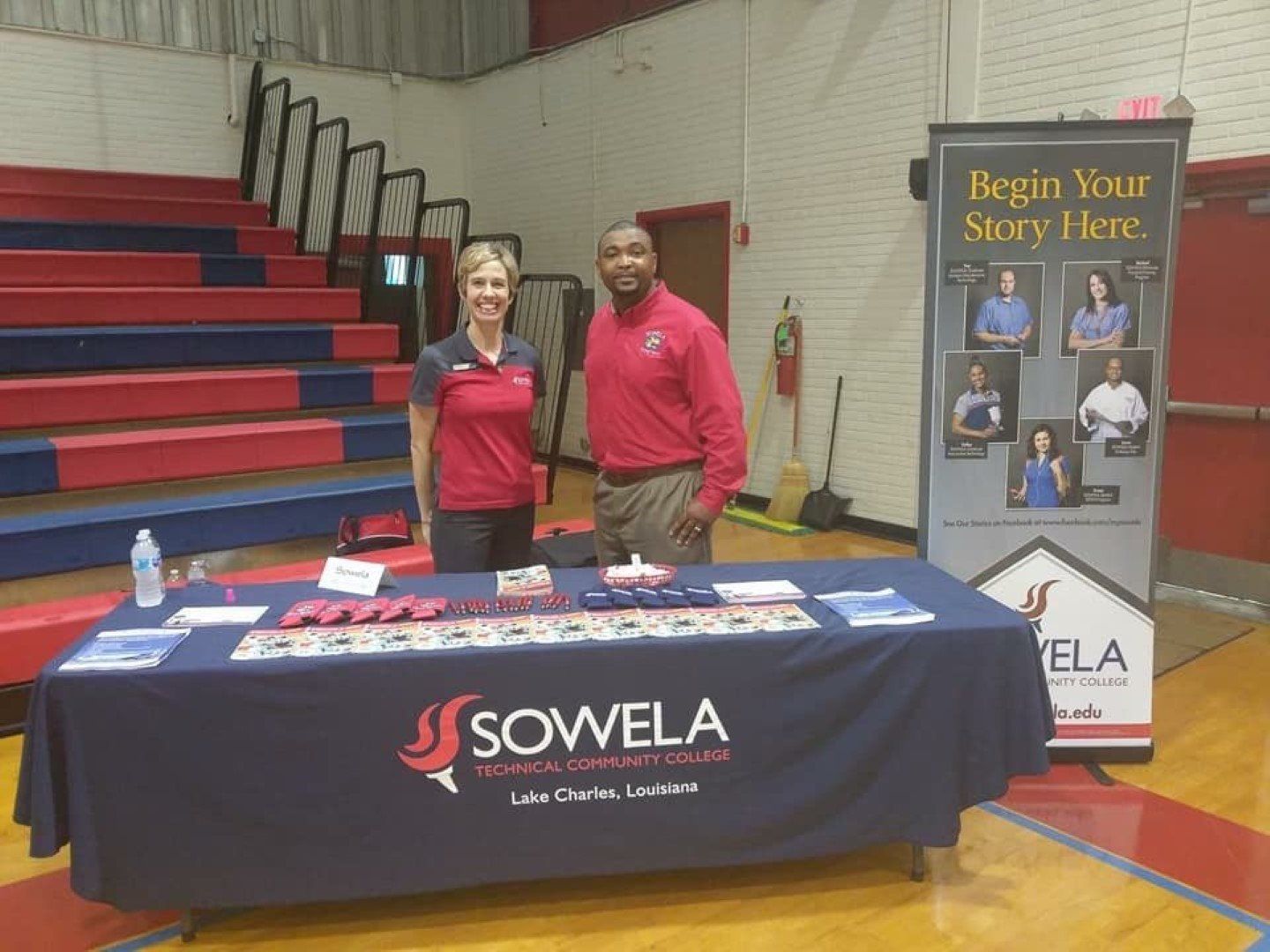 A man and a woman are standing in front of a table that says sowela on it