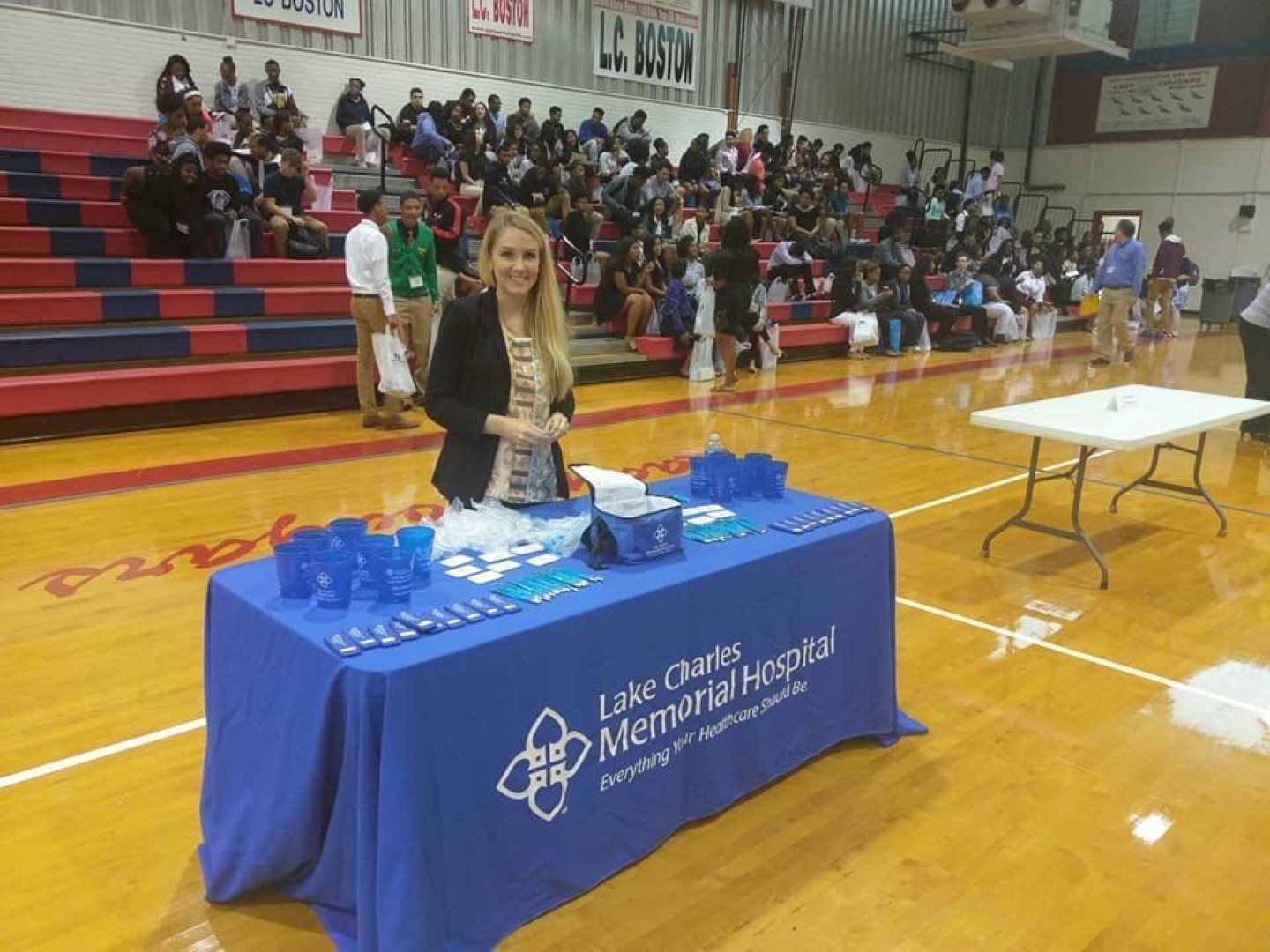 A woman is standing in front of a table that says lake charles memorial hospital