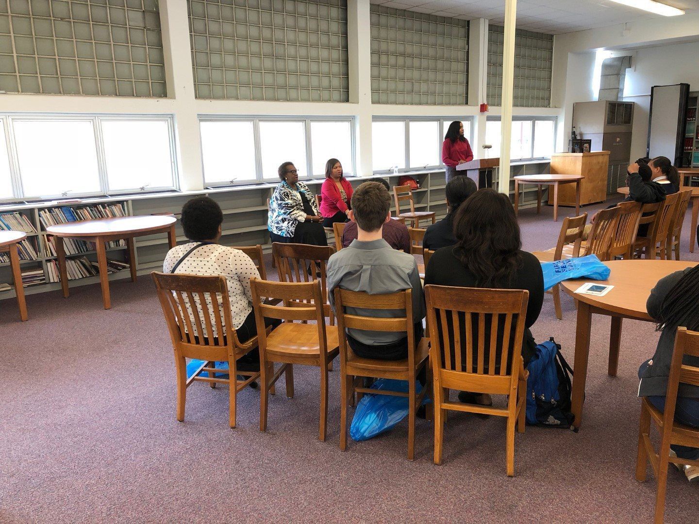 A group of people are sitting in chairs in a library.