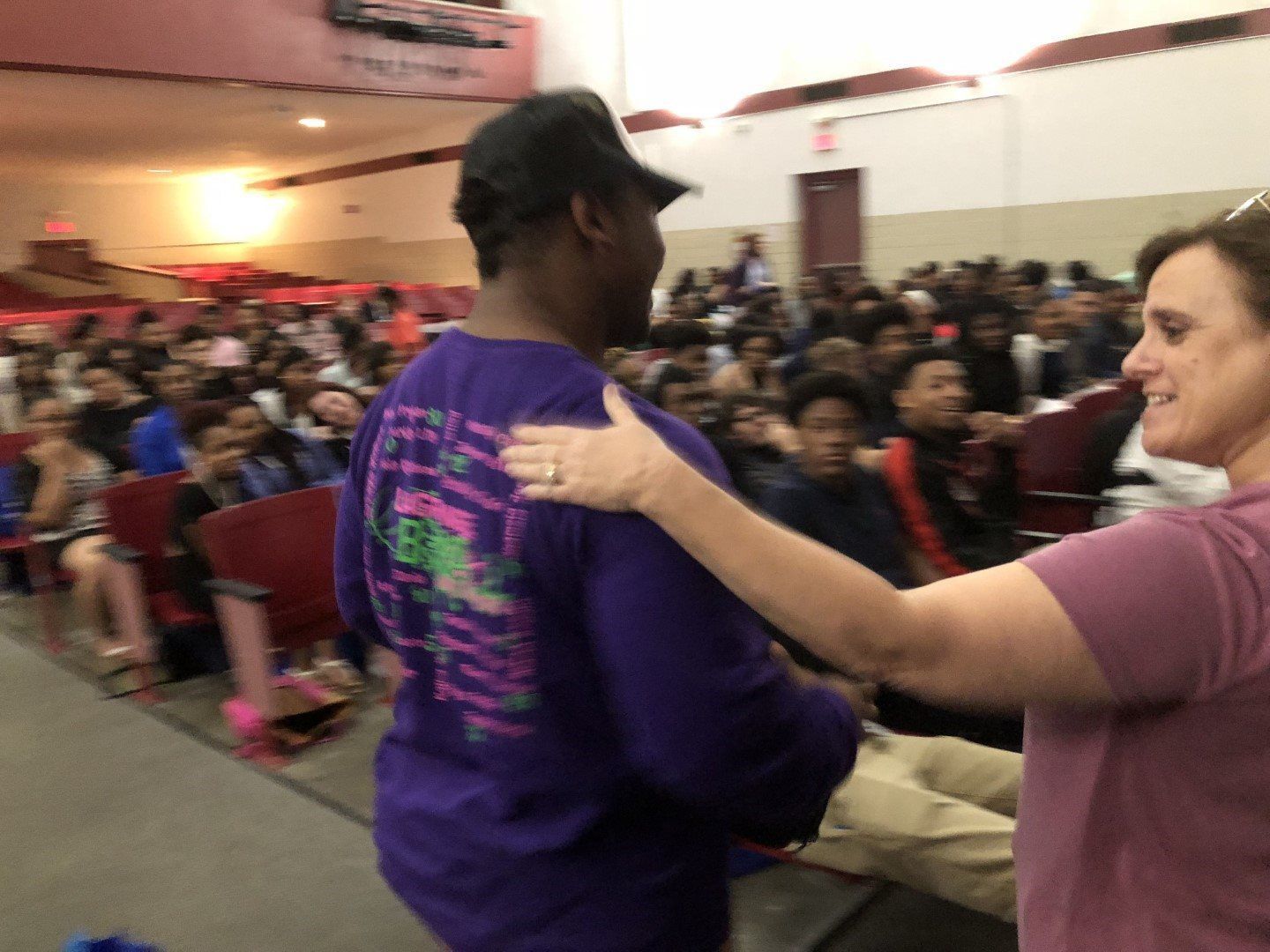 A woman is hugging a man in a purple shirt