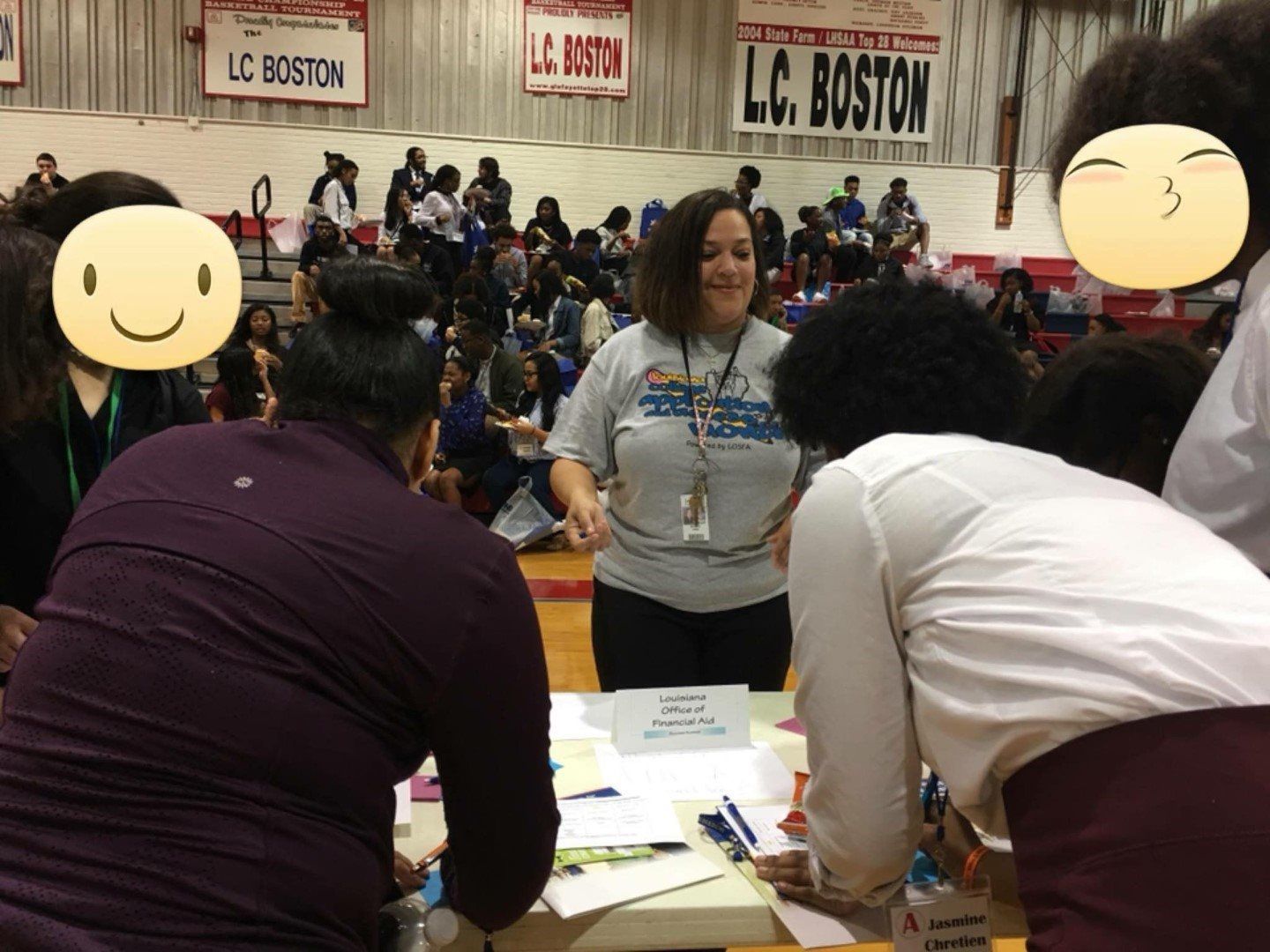 A group of people are gathered around a table with a sign that says lc boston on it