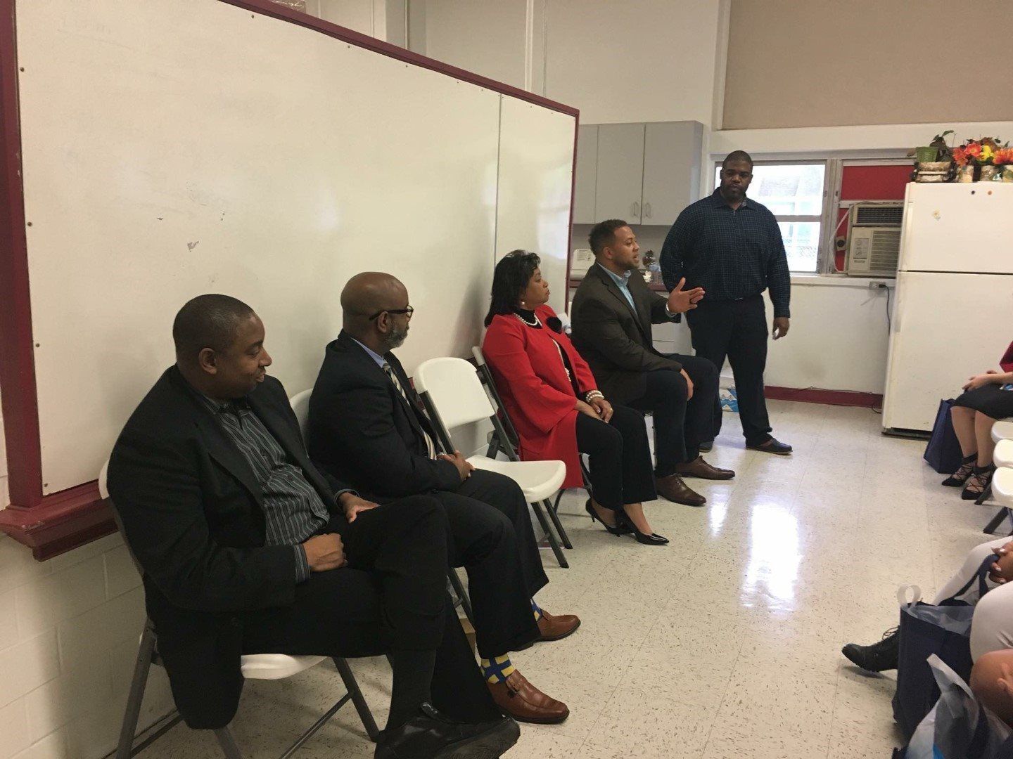 A group of people are sitting in chairs in a room.