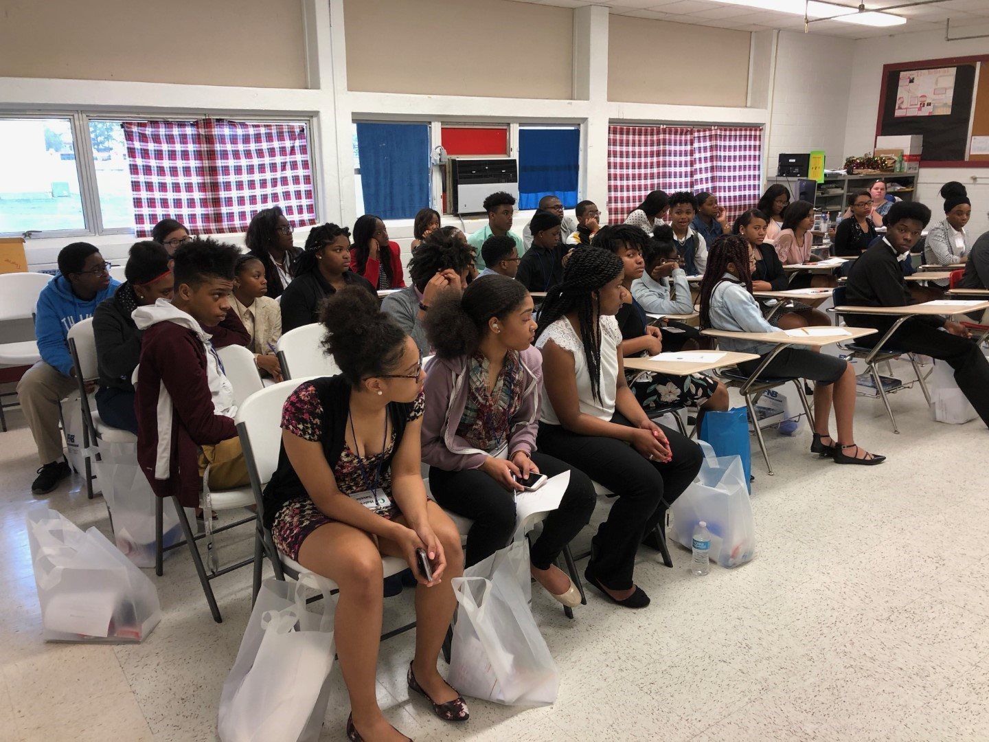 A group of people are sitting in chairs in a classroom
